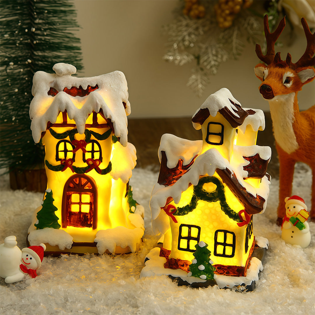Lighted ceramic Christmas village house with snowy roof and warm yellow lighting.