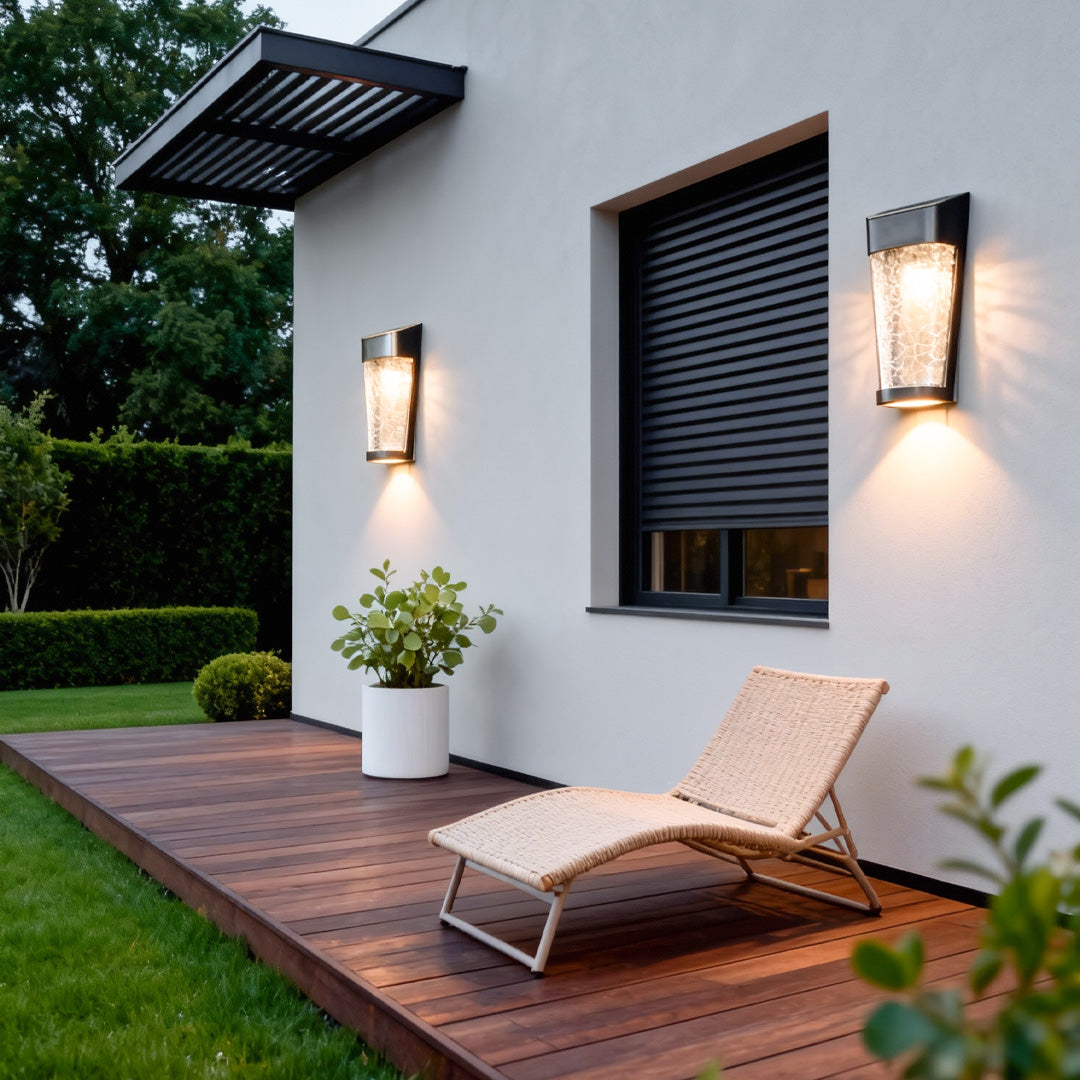 A glowing outdoor wall lantern installed beside a cozy patio area, adding inviting and atmospheric lighted outdoor wall decor.