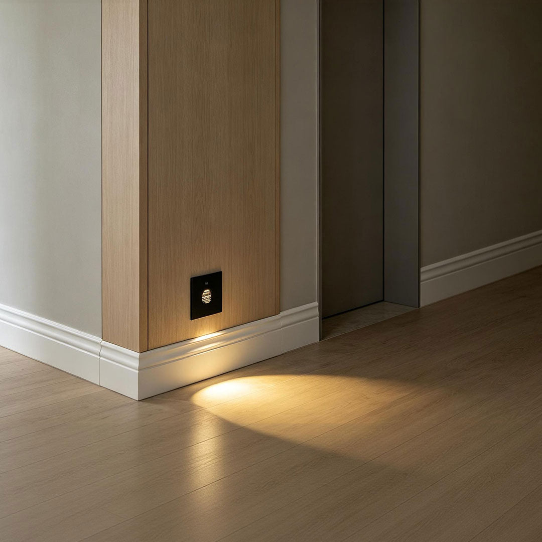 Lights for indoor steps installed along a hallway wall providing soft floor-level guidance lighting.