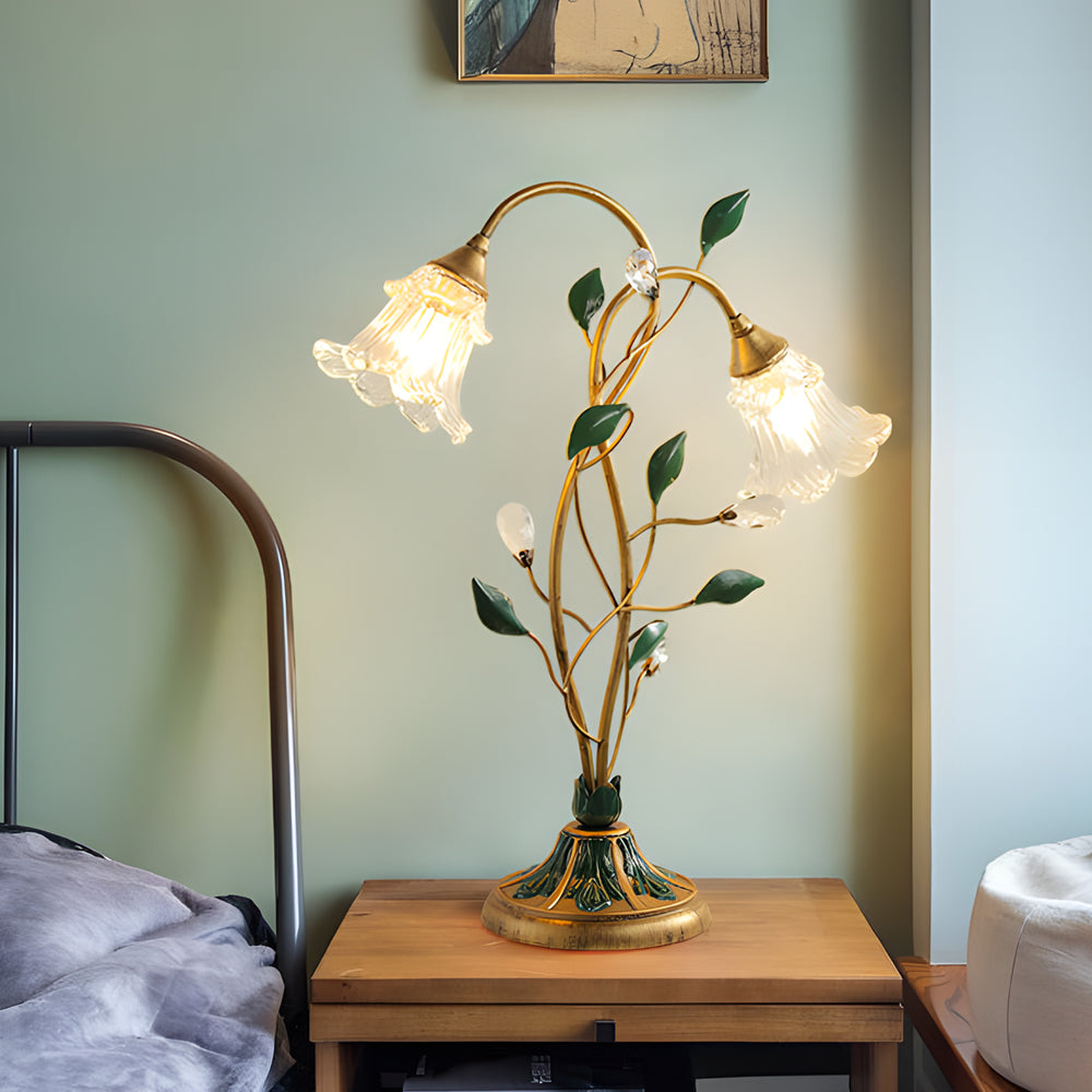Lily table lamp providing elegant illumination beside a minimalist bed.