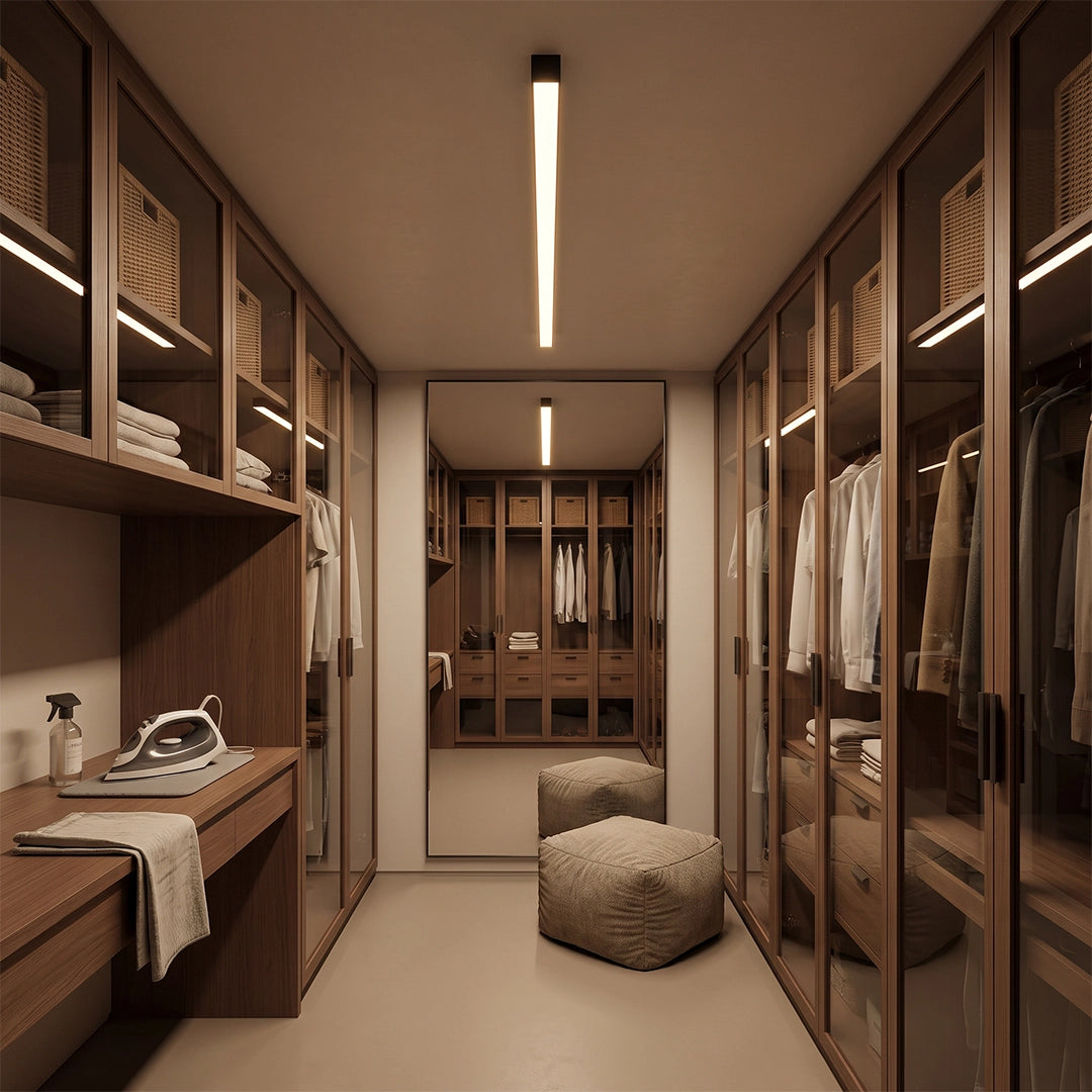 Linear ceiling light installed in a modern walk-in closet, providing sleek overhead illumination above wood cabinetry and dressing space.