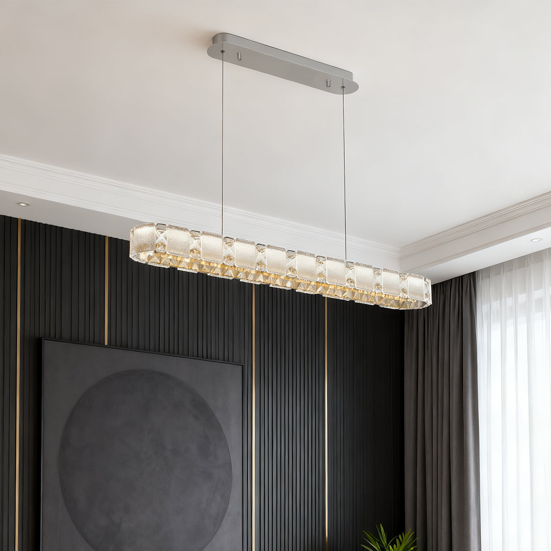 Long linear chrome chandelier illuminating modern hallway entrance with crystal accent lighting