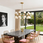 Bubble glass chandeliers in a linear design, featuring many clear crystal orbs and a polished chrome finish over a modern dining table.