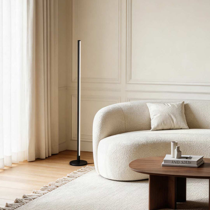 Linear floor lamp illuminating a cozy modern living room with warm ambient glow.