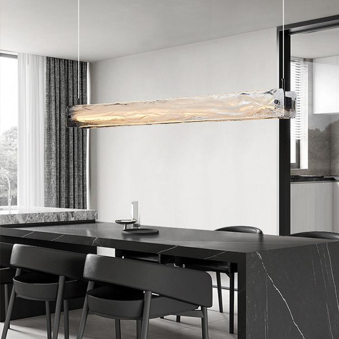 Linear glass pendant light for kitchen illuminating modern dining space with black accents