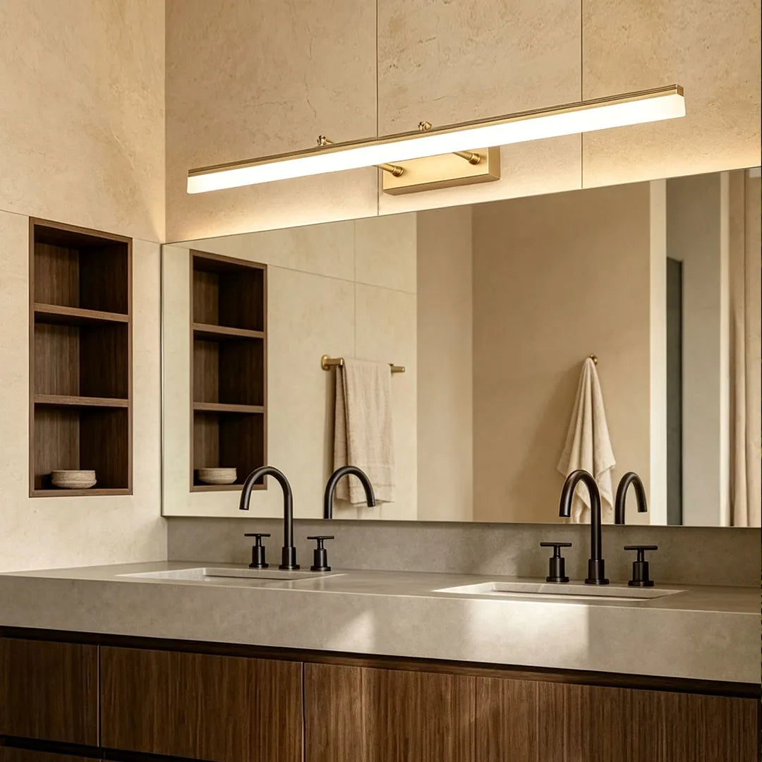 Linear gold bathroom vanity lights installed over a wide mirror in a modern double vanity bathroom.