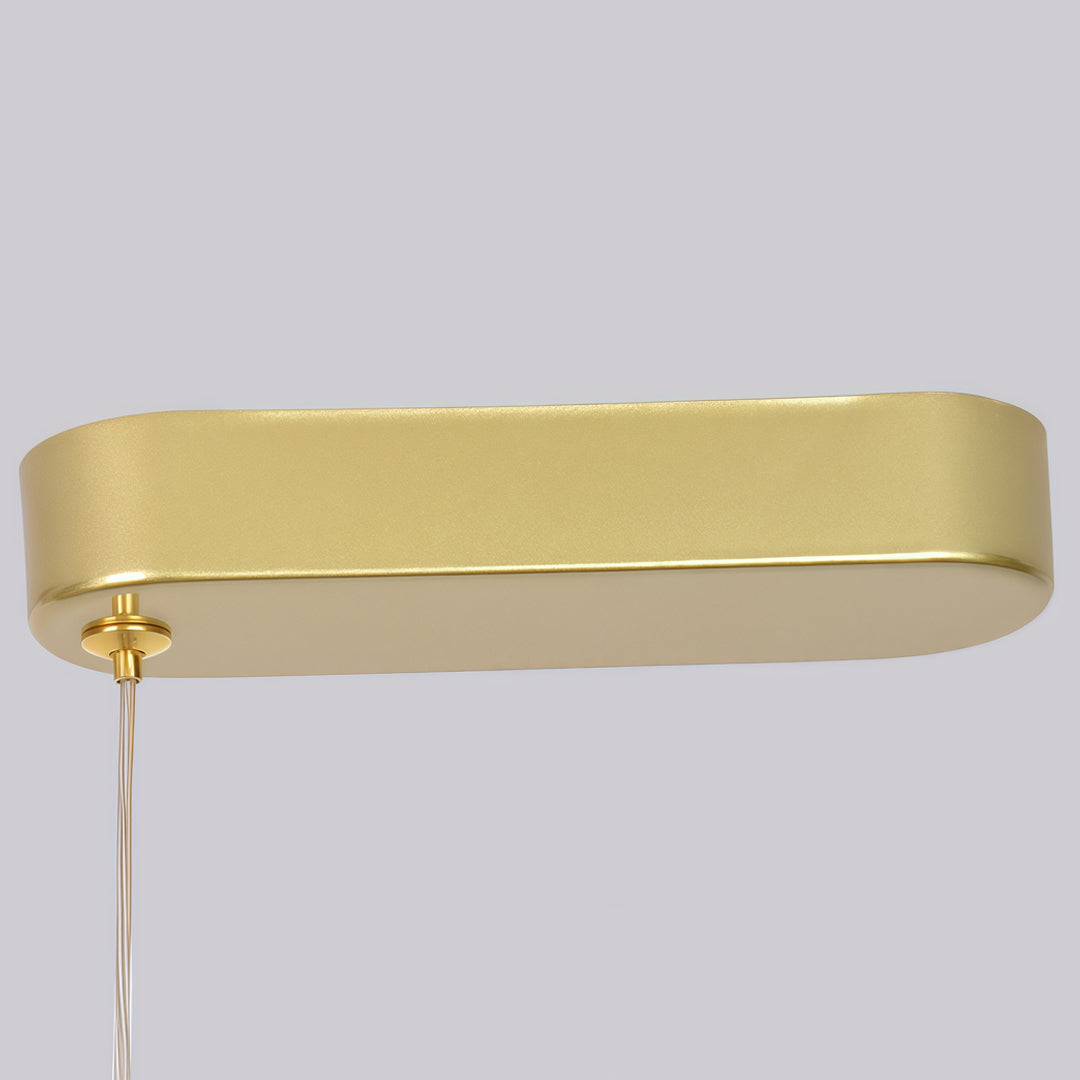 Detailed view of linear gold pendant light canopy and suspension cable connection.