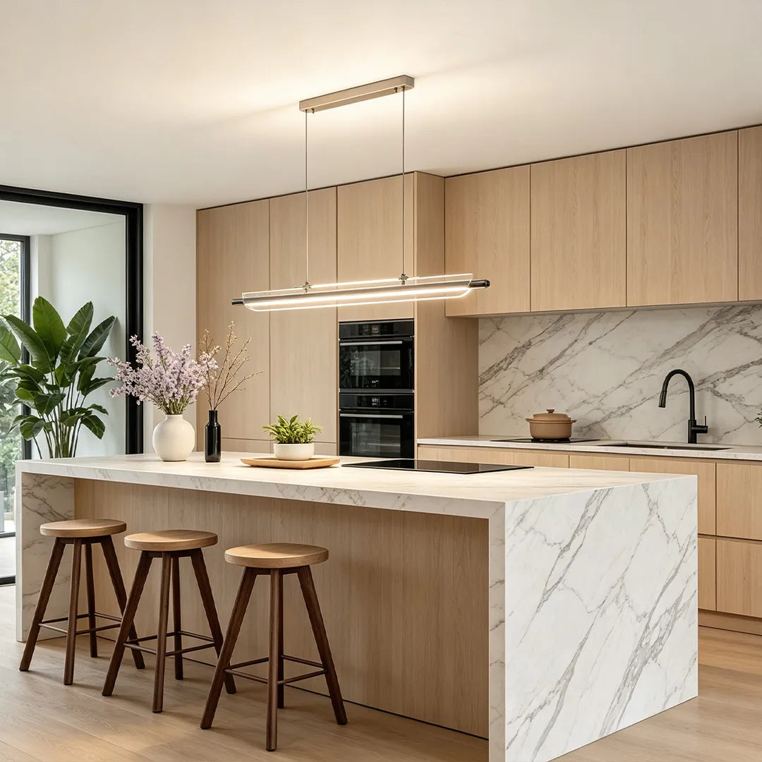 Linear LED pendant light above a marble kitchen island in a modern wood-finish interior.