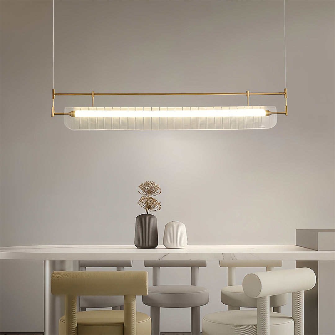 Linear light pendant creating ambient lighting in minimalist dining room with beige and white tones.