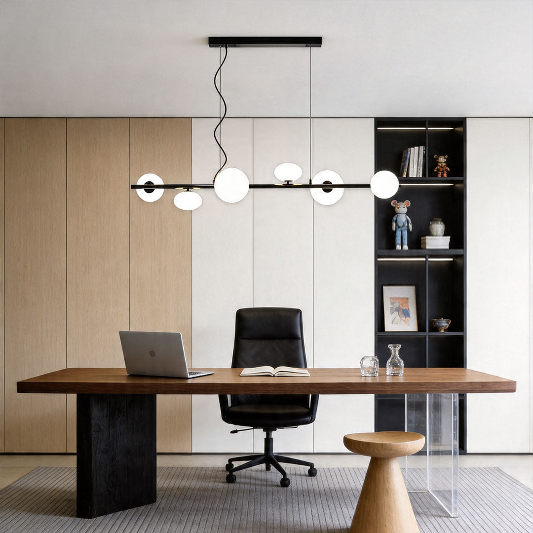 Linear modern chandelier above a desk in a modern home office with wood panel wall background.