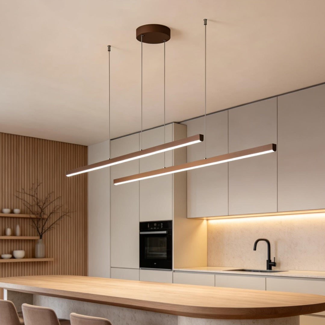 Minimalist linear pendant light fixture over wooden kitchen counter.