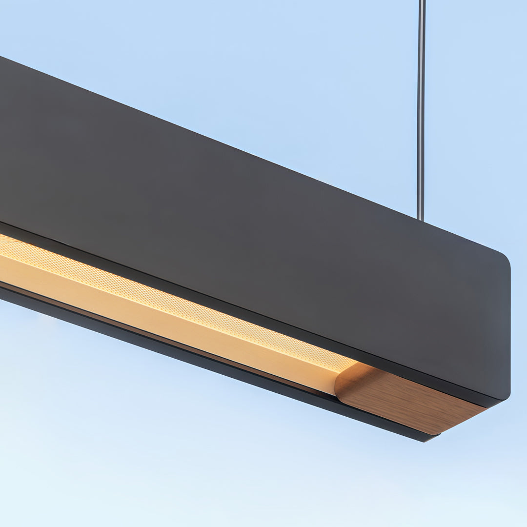 Close-up detail of black linear pendant light fixtures with integrated warm LED lighting.