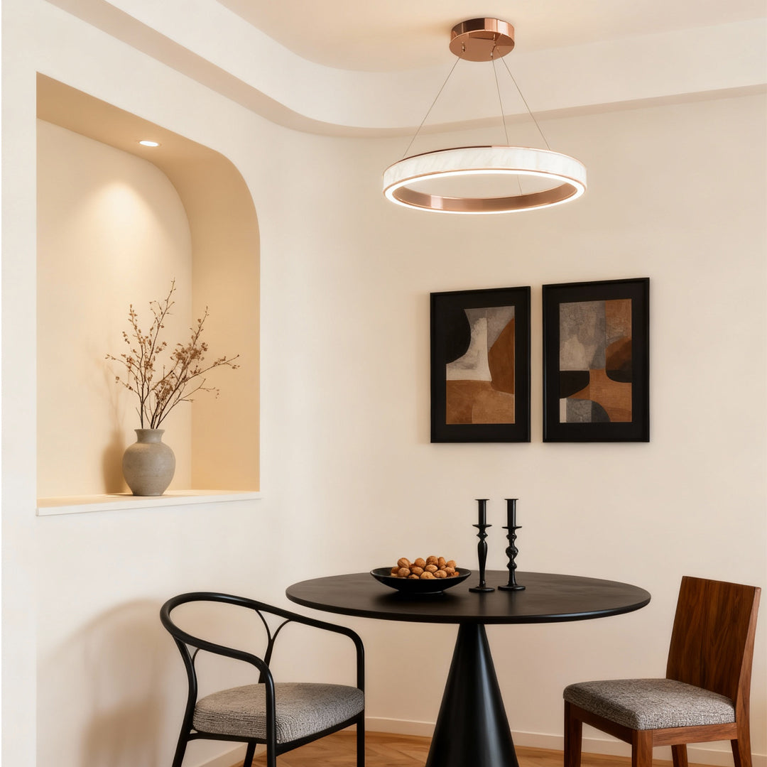 Warm dining nook lit by modern linear suspension light fixtures with a clean circular ring design.