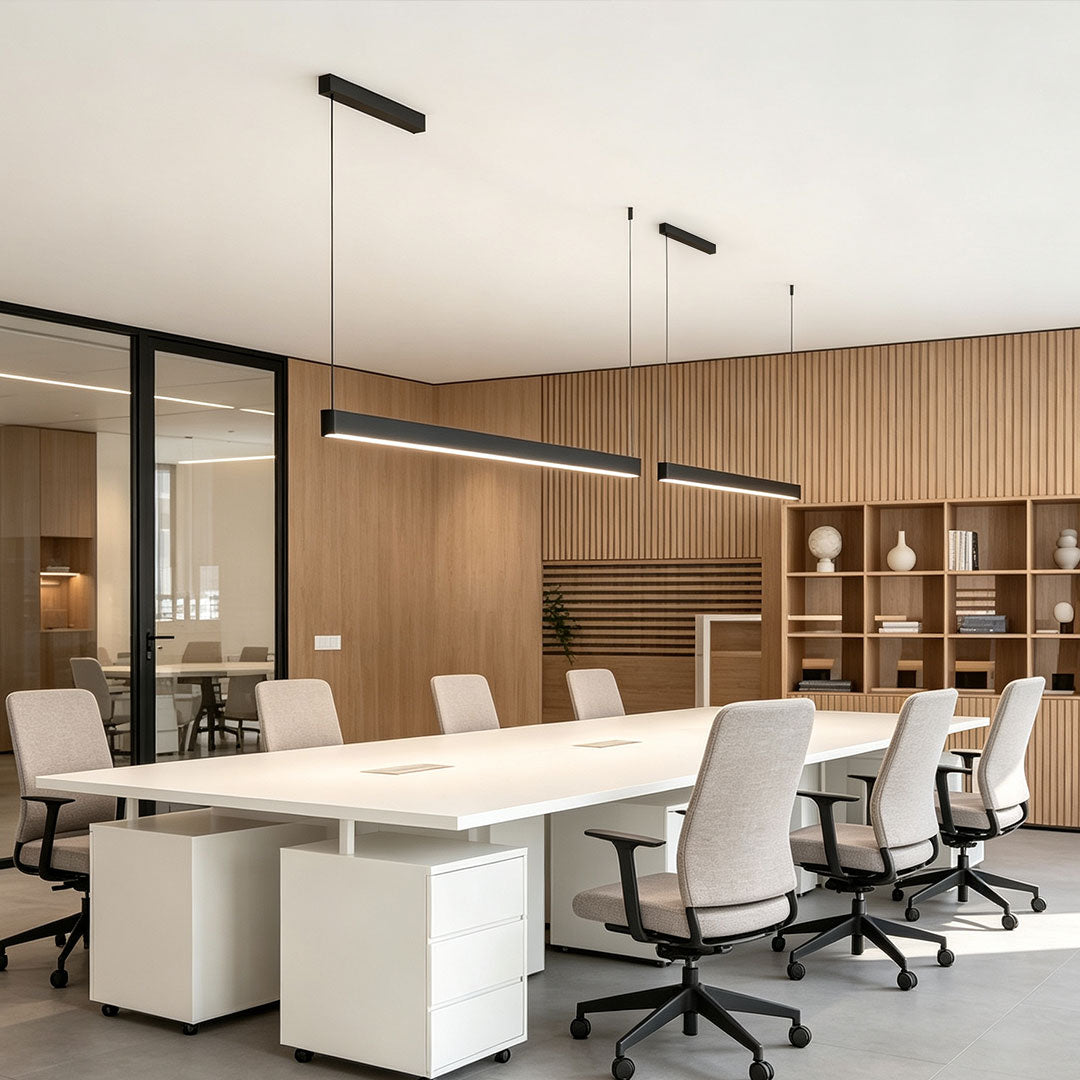 Modern linear suspension light installed above a contemporary office conference table.