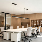 Modern linear suspension light installed above a contemporary office conference table.