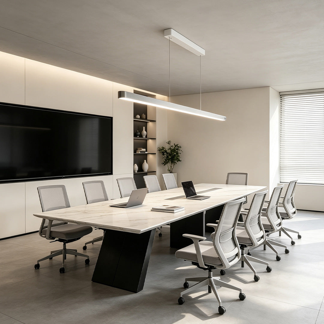 Slim linear suspension lighting fixtures illuminating a conference room with clean contemporary aesthetics.