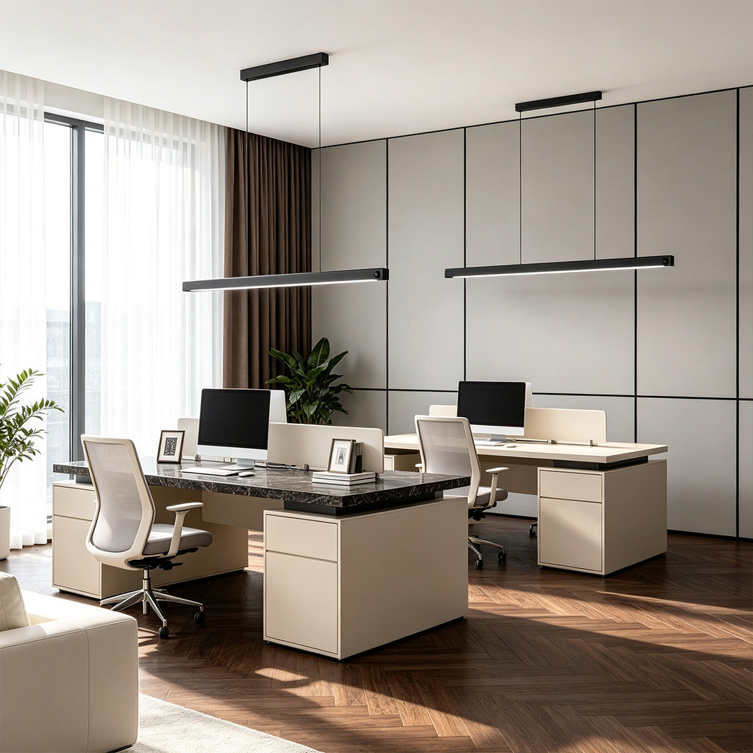 Contemporary linear suspension lighting fixtures hanging above modern office workstations in a stylish interior.