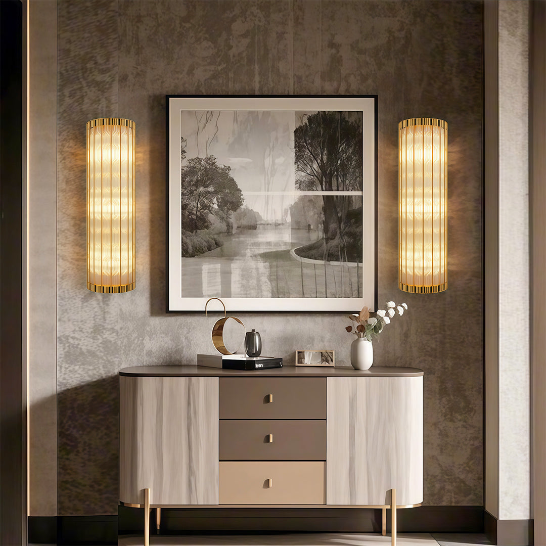 Mounted hanging linear wall light pair flanking bathroom mirror above white vanity.