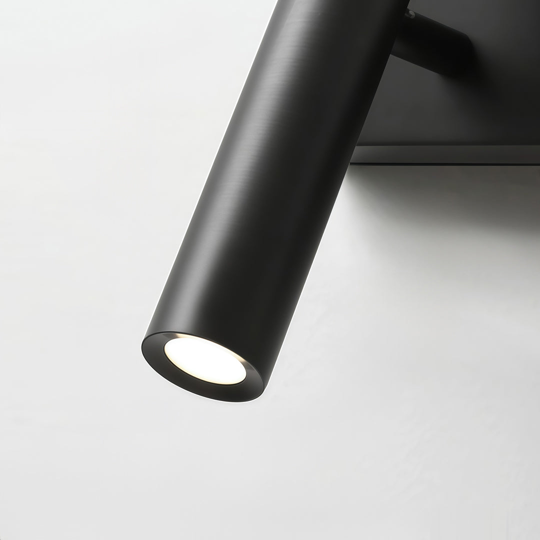 Close-up detail of black linear wall sconces with cylindrical spotlight and matte finish design.