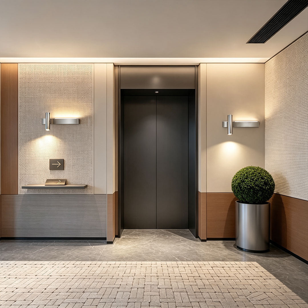 Elegant linear wall sconces illuminating a luxury hotel hallway with contemporary interior design.