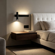 Modern linear wall sconces installed beside a bed with warm ambient lighting in a minimalist bedroom.