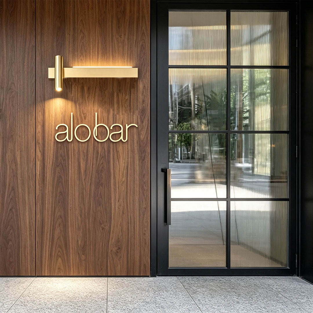 Modern linear wall sconces featured on wooden exterior wall near glass entrance with warm lighting.