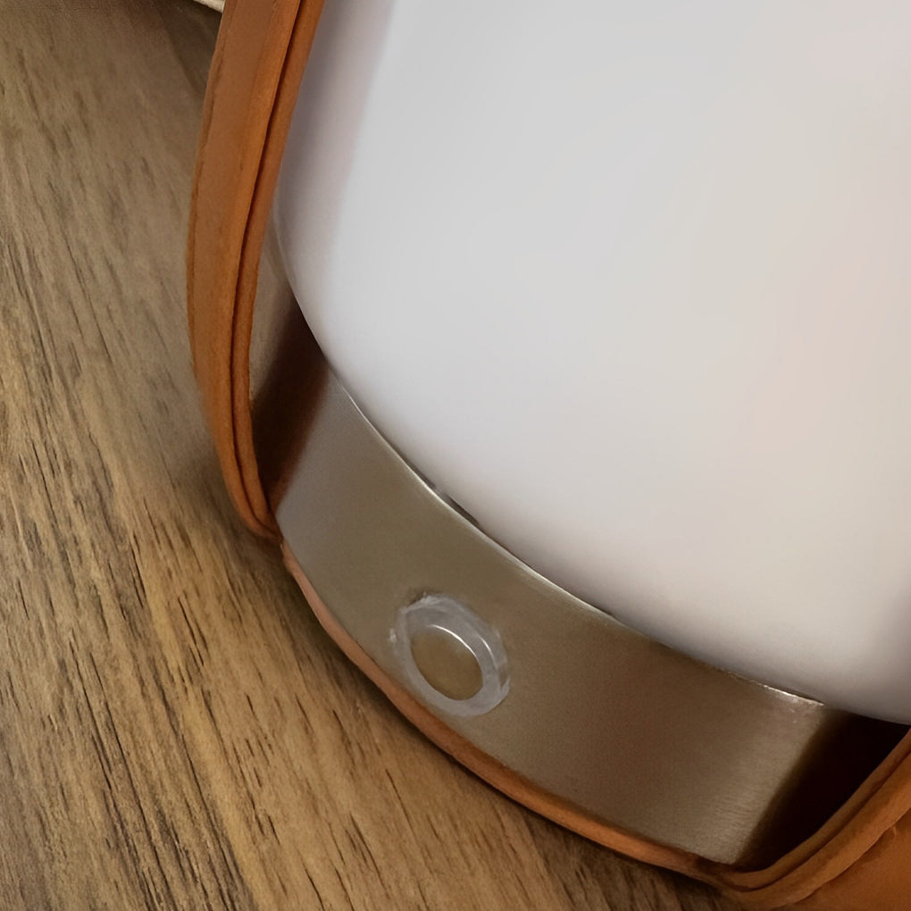 Liquor bottle lights with a close-up of their leather strap and metal button.