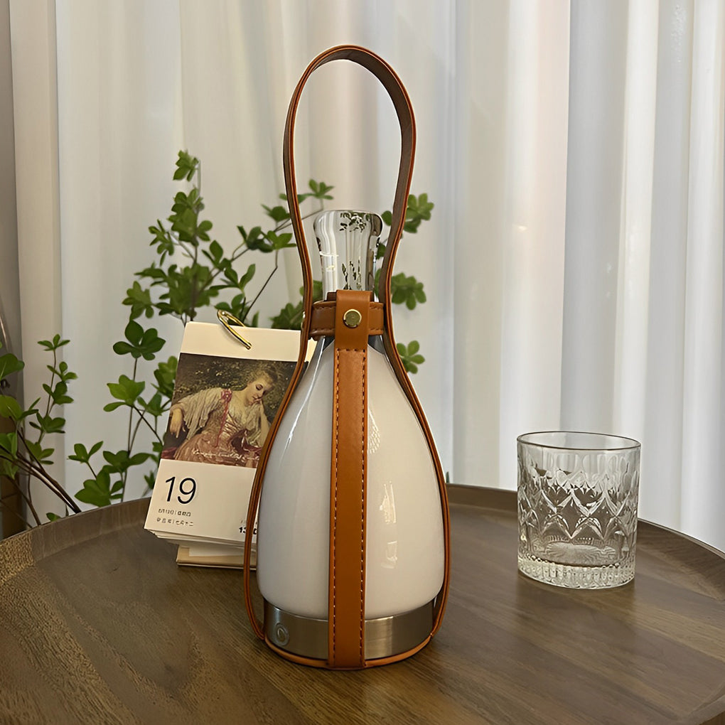 Liquor bottle lights with a leather handle, providing soft light near a plant.
