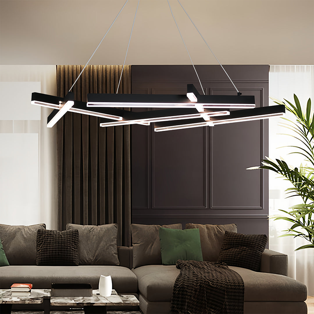 Small black pendant light chandelier illuminating modern living room with dark wood accents