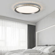 Round flush mount LED light mounted in elegant living room with white curtains and modern decor