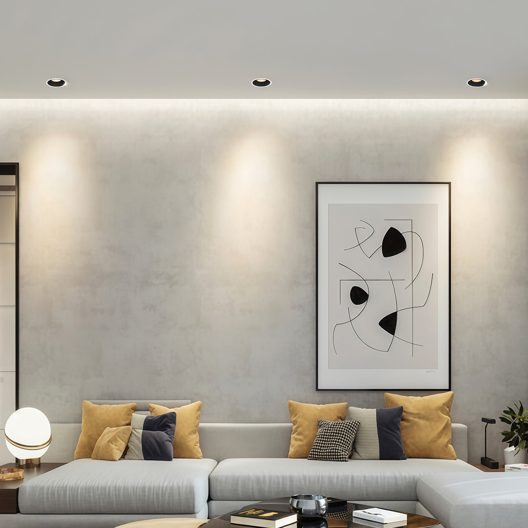 Contemporary living room wall-wash effect using multiple led downlight recessed fixtures over a sofa.