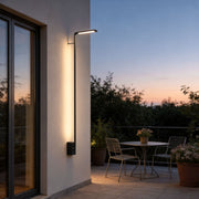 Long outdoor wall lights with a modern linear design, mounted beside a glass door.