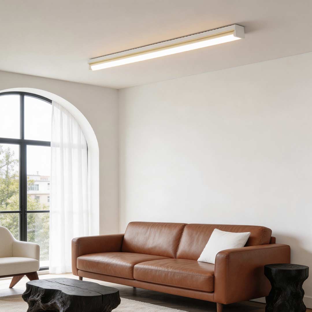 Long strip ceiling light providing bright illumination in a modern living room with large windows.