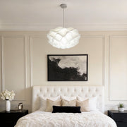 Lotus flower pendant light illuminating a modern bedroom with soft, ambient glow.