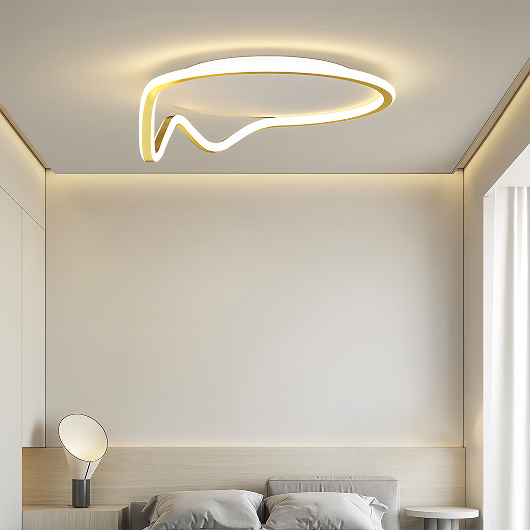 Low-profile white and gold geometric flush mount light used in a bright, modern interior space, highlighting the curved design.
