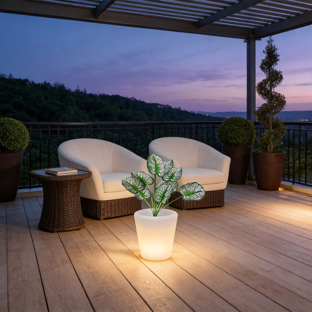 Luminous flower pots illuminating a cozy patio seating area with white chairs at dusk.