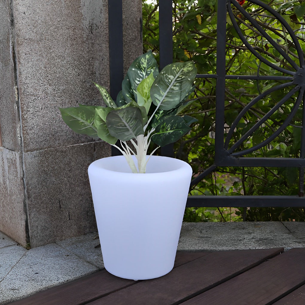 Luminous flower pots providing soft light on a modern balcony with stone walls.