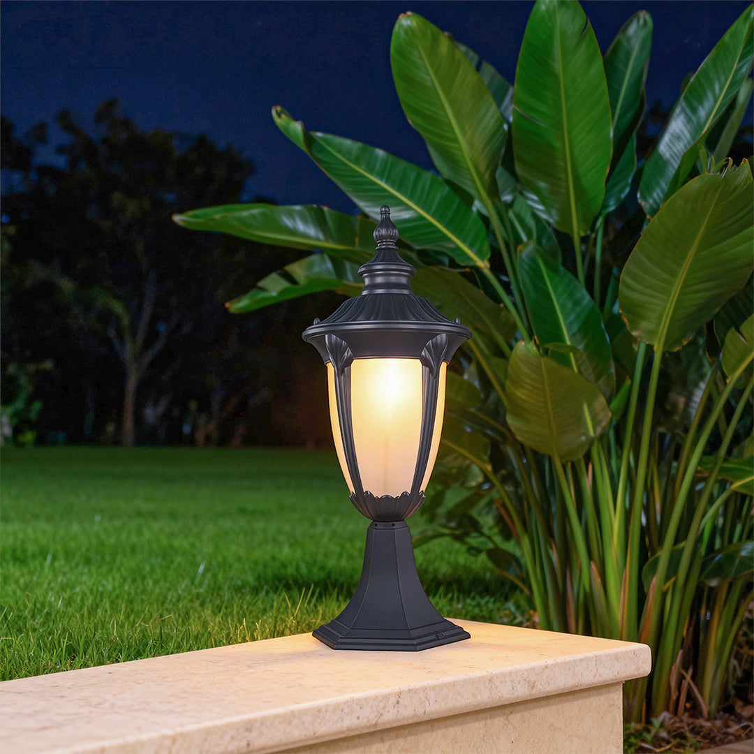 Exterior pillar light in a lush garden setting, warm and inviting outdoor lighting fixture