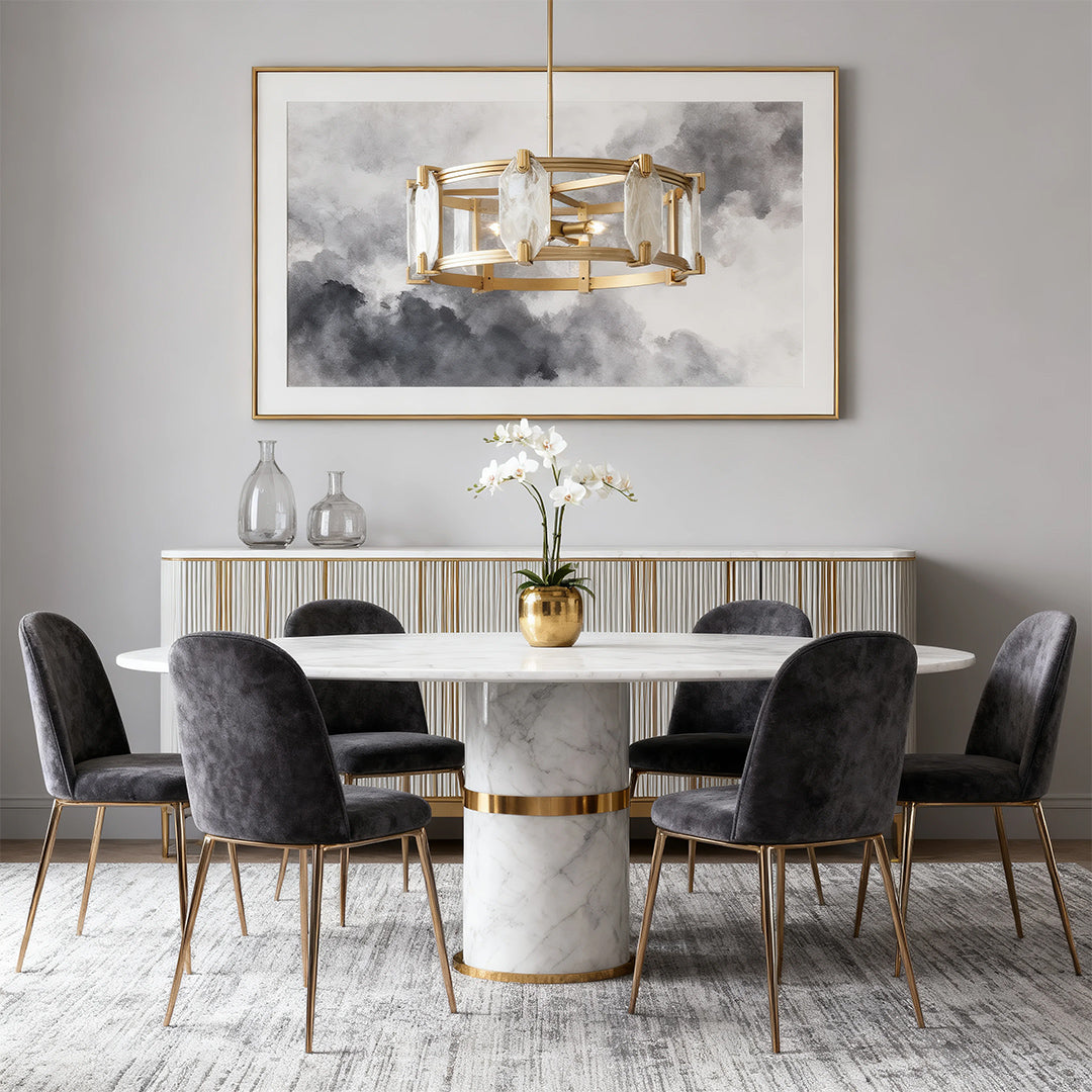 Luxurious round glass chandelier with a gold metal frame and clear crystal accents, suspended over a marble dining table in a contemporary gray room.