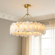 Luxurious gold and white frosted petal modern LED chandelier hanging in an elegant room with natural light.