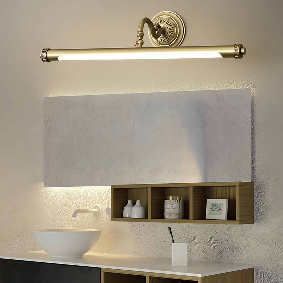 Gold bathroom vanity light mounted above mirror in luxurious bathroom with marble surfaces