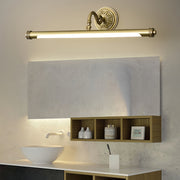 Gold bathroom vanity light mounted above mirror in luxurious bathroom with marble surfaces
