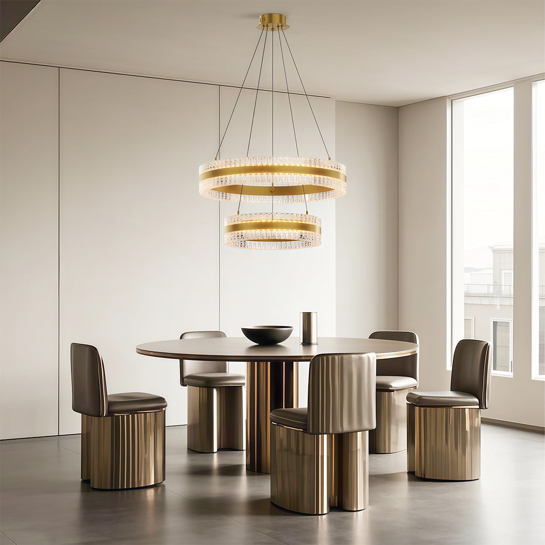 Luxurious modern circular chandelier with dual rings, hanging above a dining table in a contemporary space.