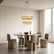 Luxurious modern circular chandelier with dual rings, hanging above a dining table in a contemporary space.