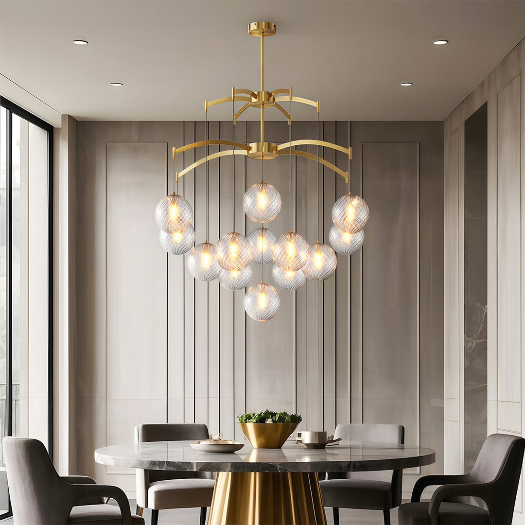 Luxurious modern glass ball chandelier with gold frame, hanging above a round dining table.