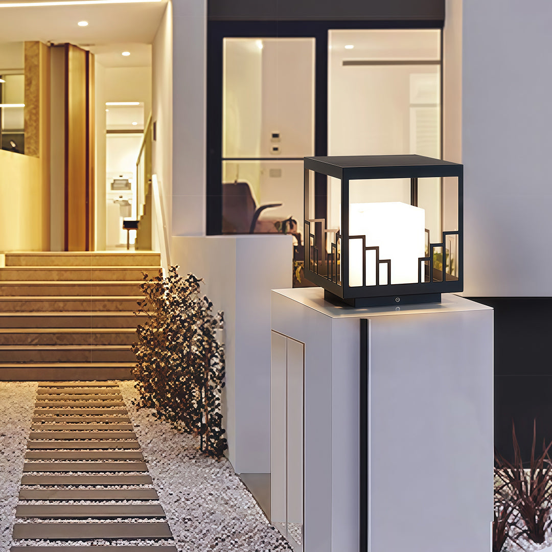 Luxurious outdoor pillar light featuring glass shade chandelier influence creating warm welcoming glow in contemporary entryway.