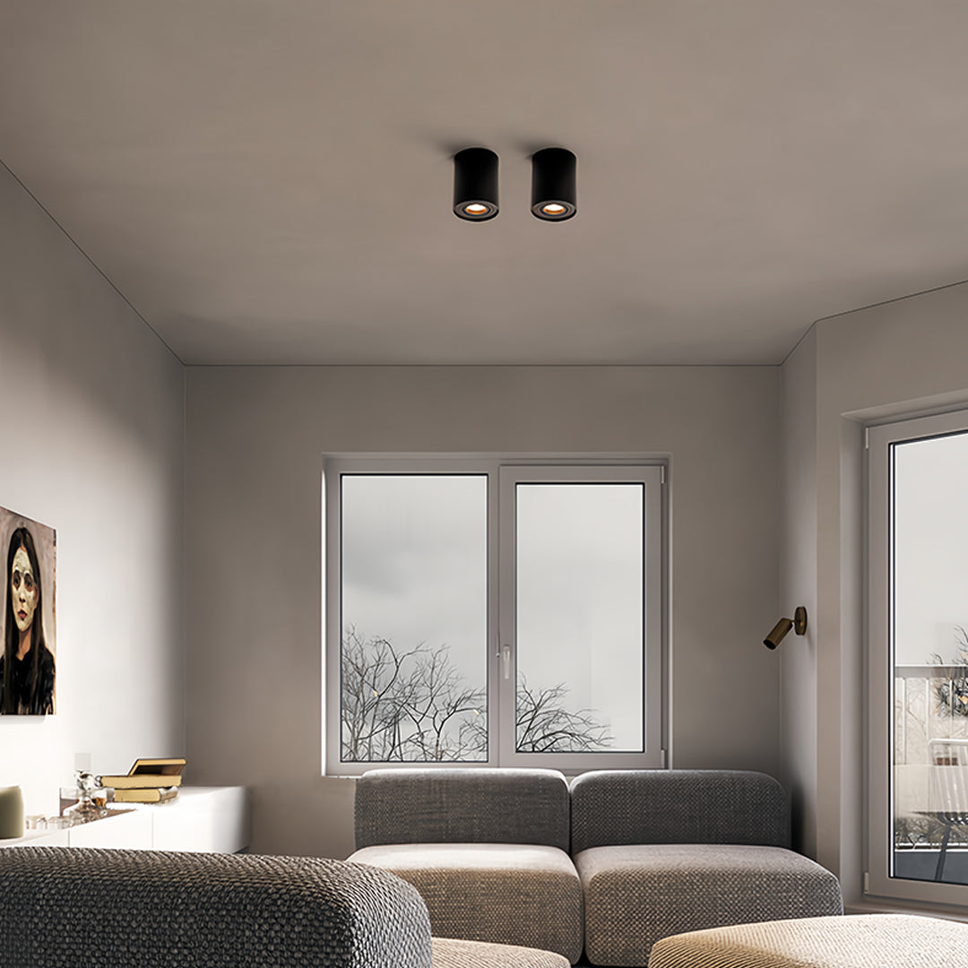 Luxury bedroom with dual black surface mounted downlight fixtures creating layered lighting scheme