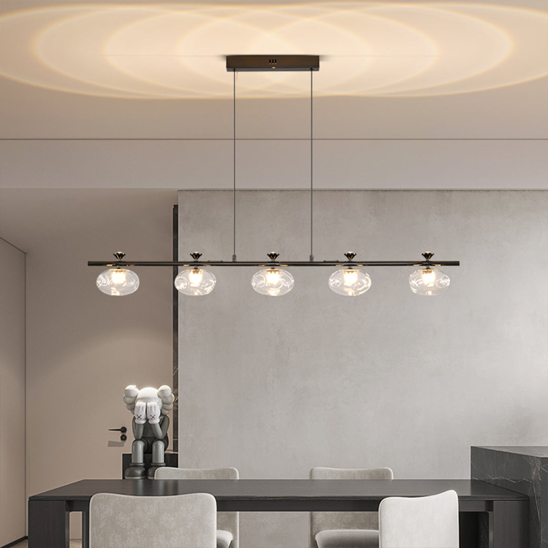 Luxury linear glass chandelier with black finish creating ambient lighting over kitchen island