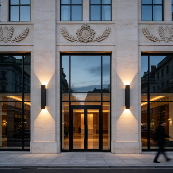 Luxury commercial entrance illuminated by black up and down wall lights with warm LED beams.