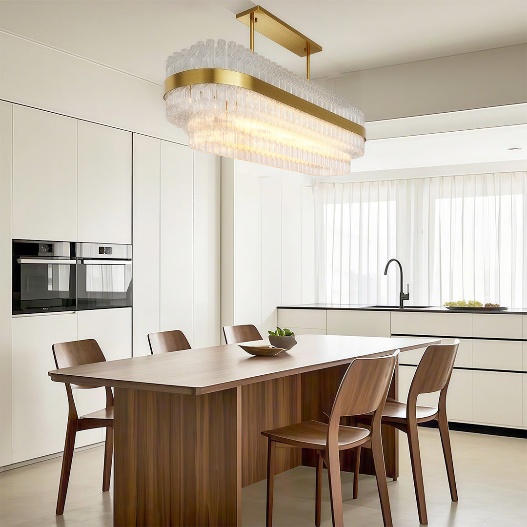 Modern luxury chandeliers illuminating bright dining area with marble kitchen island